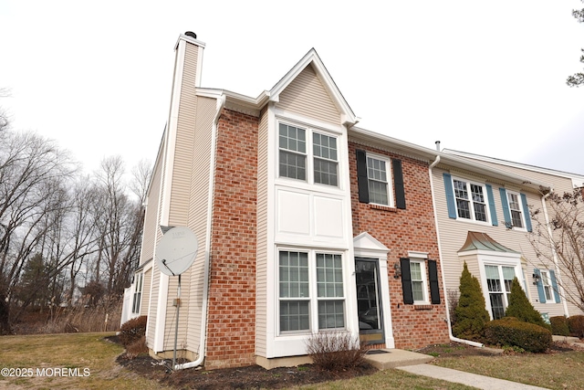 multi unit property with brick siding and a chimney