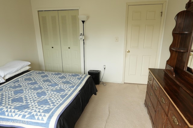 bedroom with a closet, light colored carpet, and baseboards