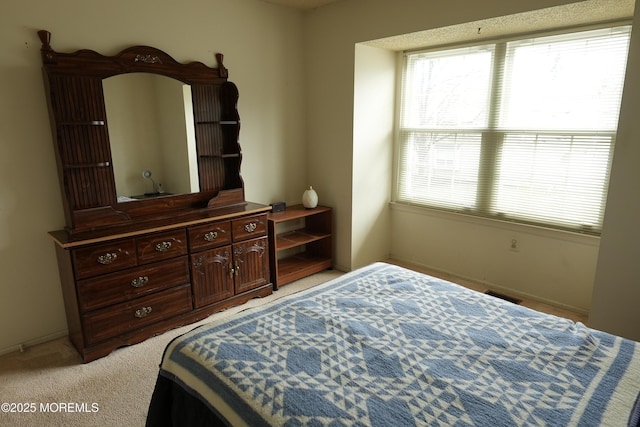 bedroom with light carpet, multiple windows, and visible vents