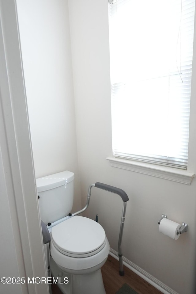 bathroom with baseboards, toilet, and wood finished floors