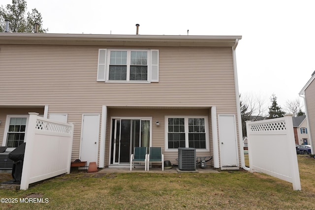 back of property with cooling unit and a lawn