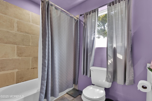 bathroom featuring toilet and shower / bathtub combination with curtain