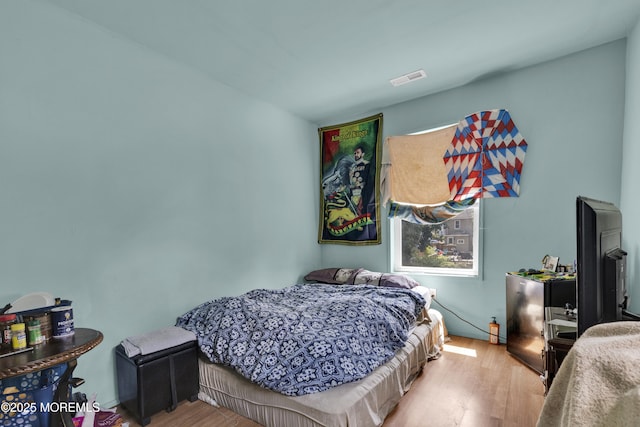 bedroom featuring visible vents and wood finished floors