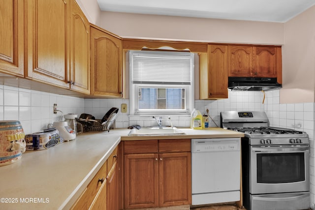 kitchen with dishwasher, light countertops, under cabinet range hood, stainless steel range with gas cooktop, and a sink