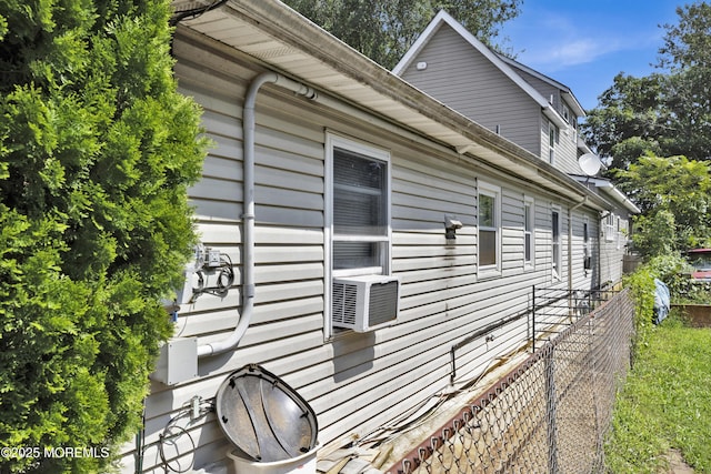 view of side of property featuring cooling unit and fence