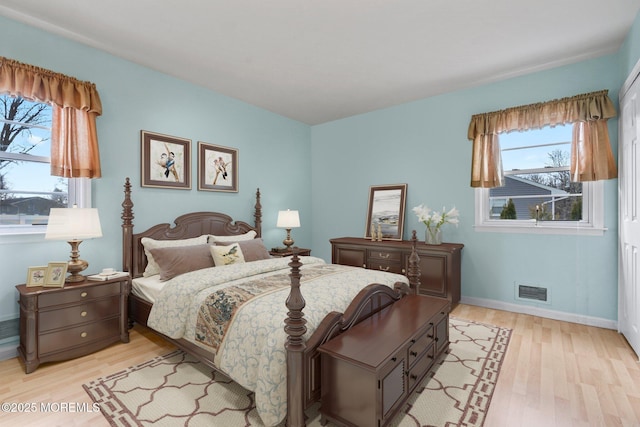 bedroom featuring visible vents, light wood-type flooring, and baseboards