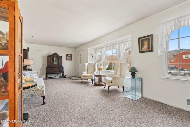 living area with carpet flooring, visible vents, and baseboards