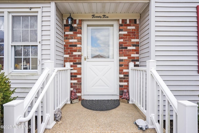 view of exterior entry featuring brick siding