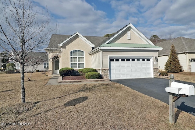 view of front of home with aphalt driveway, stone siding, metal roof, and an attached garage