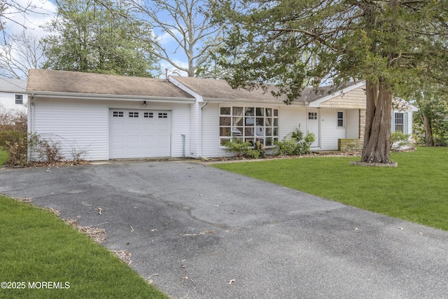 single story home featuring a front lawn, driveway, and an attached garage