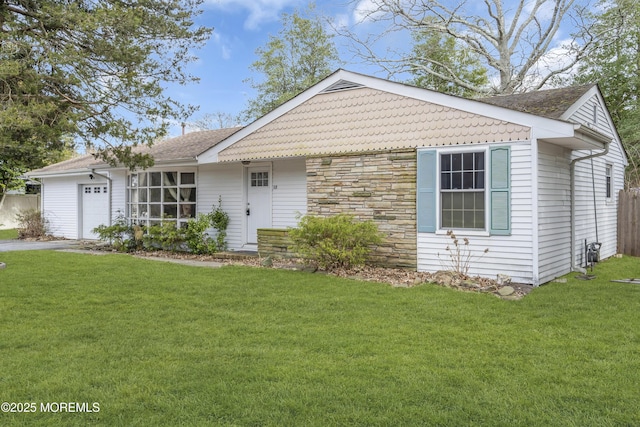 single story home with a front lawn, stone siding, and an attached garage