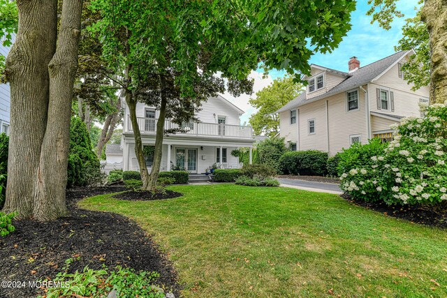 view of front of home with a front lawn and a balcony