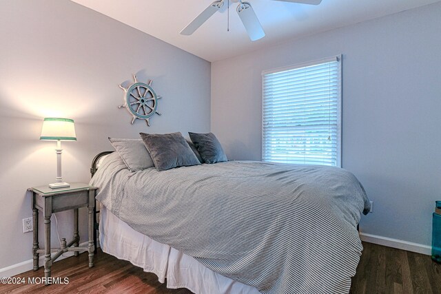 bedroom with a ceiling fan, baseboards, and wood finished floors