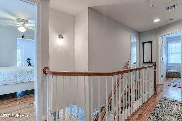 hall featuring attic access, visible vents, wood finished floors, an upstairs landing, and recessed lighting