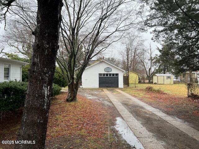 exterior space with a garage, an outbuilding, and concrete driveway