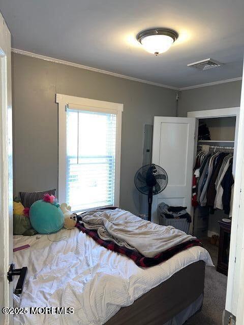 bedroom featuring visible vents, a closet, and ornamental molding