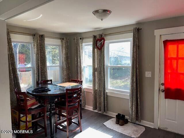 dining area featuring dark wood-style flooring and baseboards