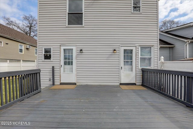 deck featuring a wall unit AC and fence