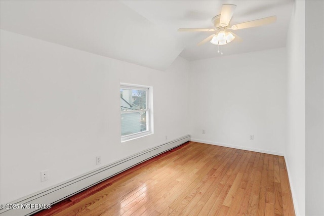 spare room featuring light wood-style floors, a baseboard radiator, ceiling fan, and baseboards