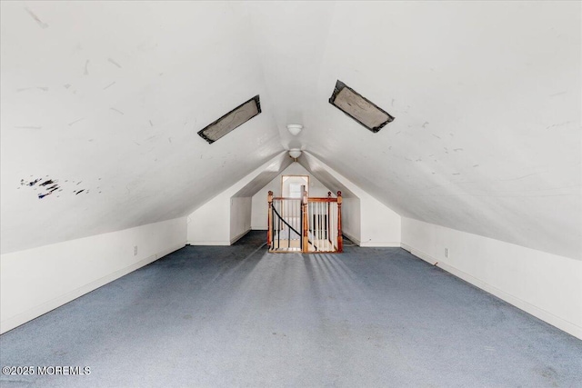 bonus room with dark colored carpet, vaulted ceiling, and baseboards