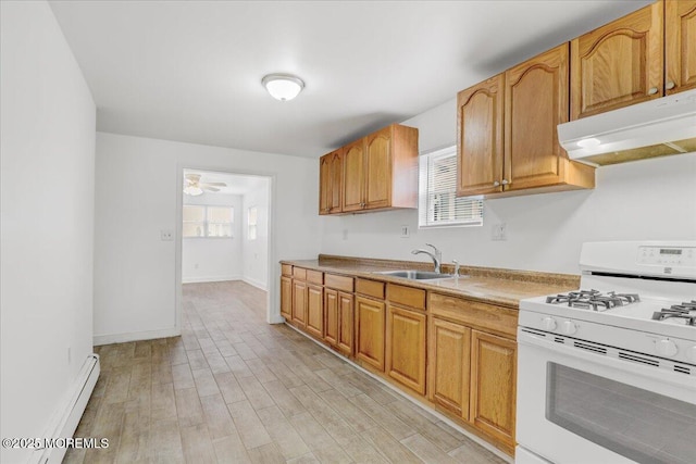 kitchen with a baseboard radiator, light wood-style flooring, under cabinet range hood, a sink, and white gas range