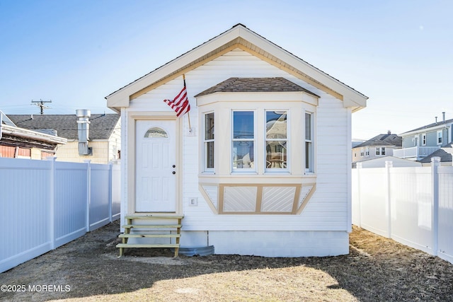 view of front of property with entry steps and a fenced backyard