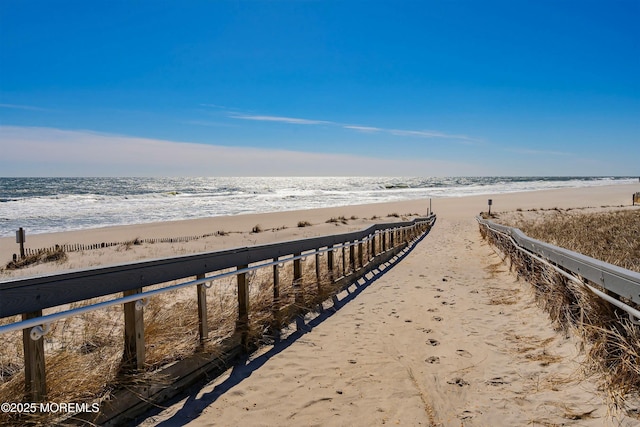 surrounding community with a water view and a view of the beach