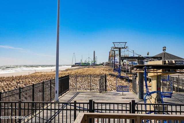 exterior space featuring a water view, fence, and a beach view