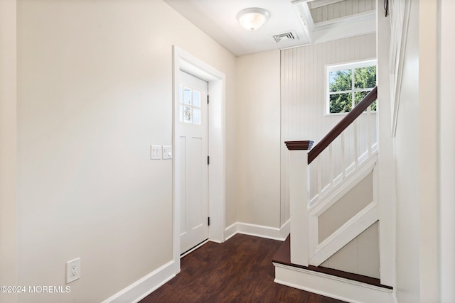 foyer with dark wood-style floors, stairs, visible vents, and baseboards