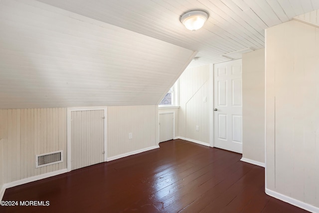 additional living space featuring baseboards, visible vents, wood ceiling, dark wood-style flooring, and vaulted ceiling