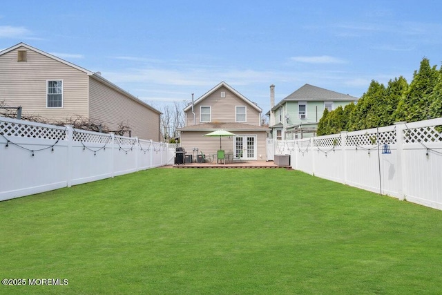 view of yard with french doors and a fenced backyard