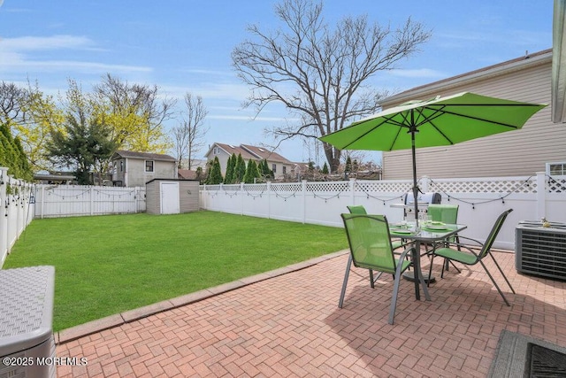 view of patio / terrace with outdoor dining space, a fenced backyard, a storage unit, and an outdoor structure