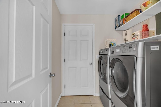 laundry room featuring laundry area, light tile patterned floors, baseboards, and separate washer and dryer