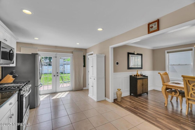 kitchen featuring wainscoting, stainless steel appliances, french doors, white cabinetry, and recessed lighting