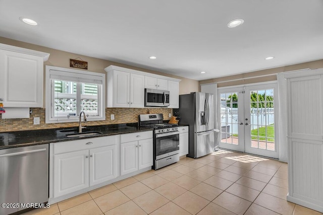 kitchen with plenty of natural light, decorative backsplash, stainless steel appliances, and a sink