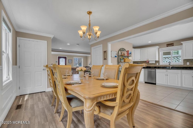 dining room with visible vents, ornamental molding, an inviting chandelier, light wood-style floors, and recessed lighting