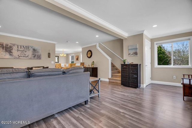 living area with a notable chandelier, stairway, ornamental molding, wood finished floors, and baseboards