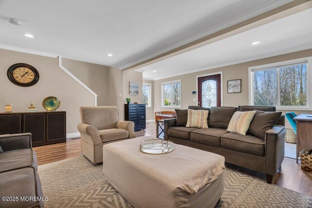 living room with baseboards, light wood-style flooring, ornamental molding, and a wealth of natural light