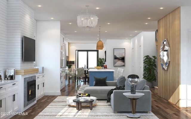 living area featuring a chandelier, a glass covered fireplace, dark wood-style flooring, and recessed lighting