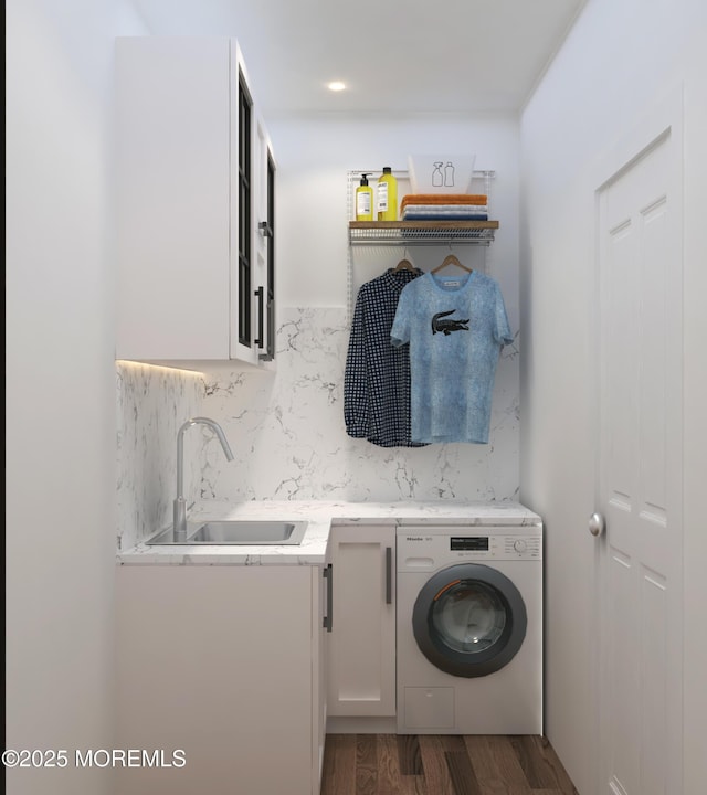 washroom with washer / dryer, dark wood finished floors, cabinet space, and a sink