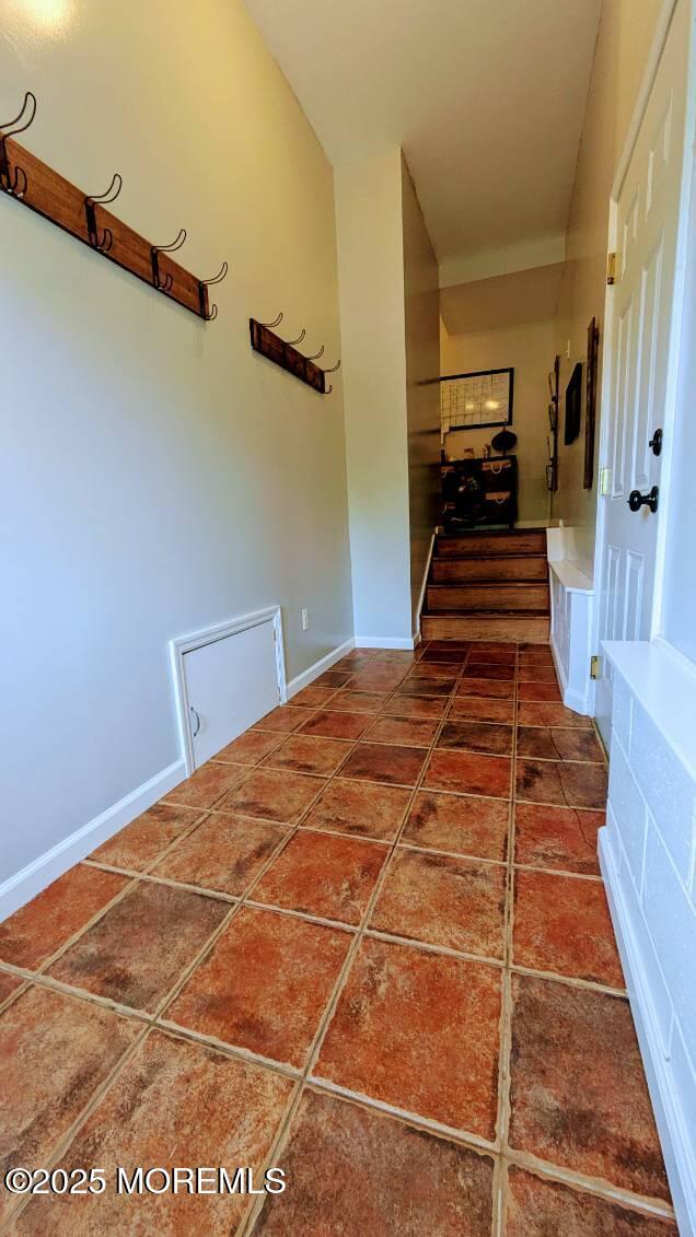 hall with tile patterned floors