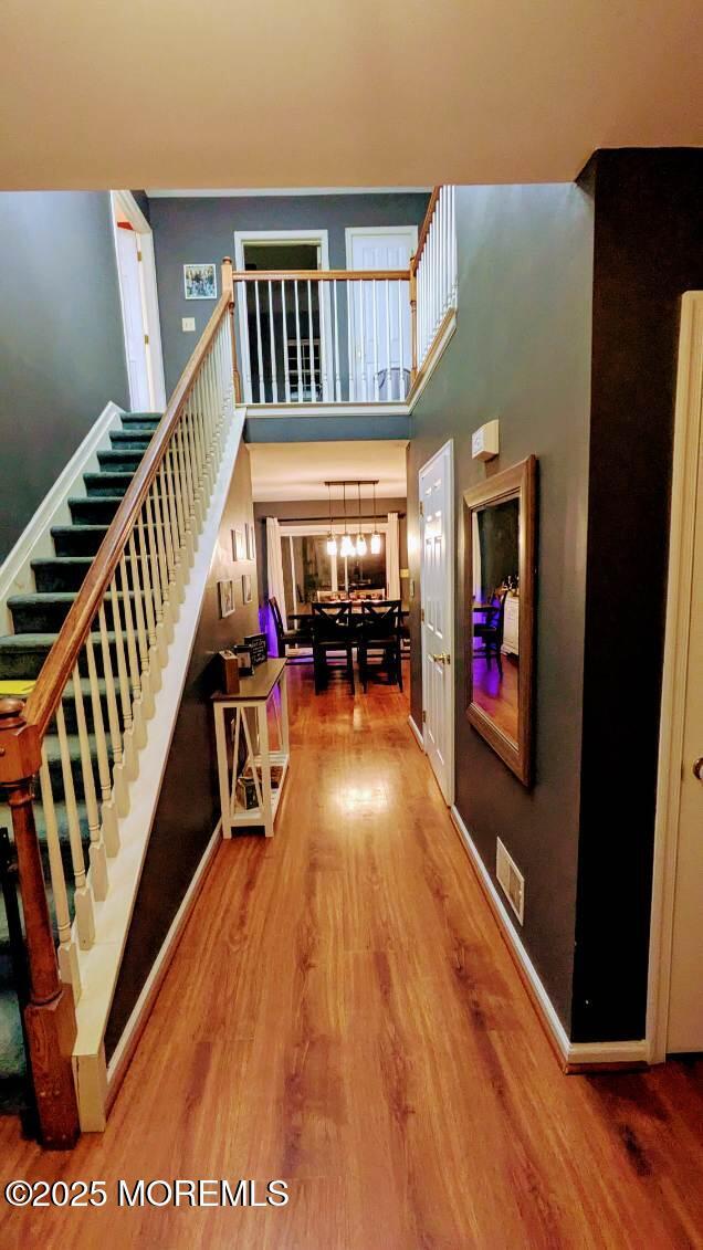interior space featuring wood finished floors, a high ceiling, visible vents, and stairway