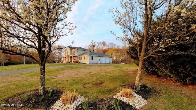 view of yard featuring aphalt driveway and an attached garage