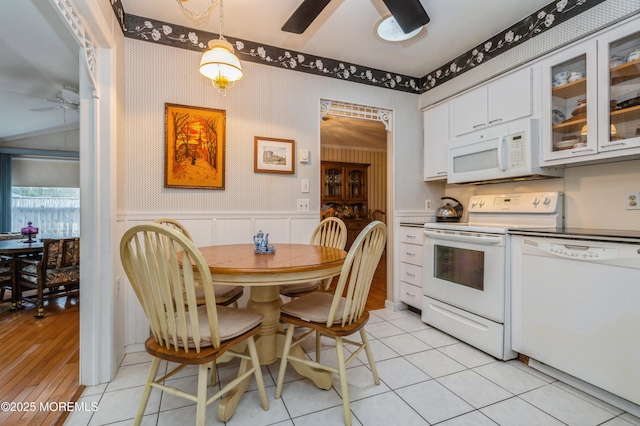 kitchen with a ceiling fan, wainscoting, white cabinetry, white appliances, and wallpapered walls