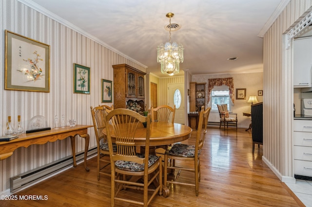 dining room with ornamental molding, light wood finished floors, an inviting chandelier, and wallpapered walls