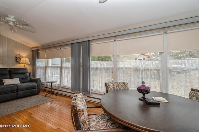 dining area featuring lofted ceiling, ceiling fan, baseboard heating, and wood-type flooring