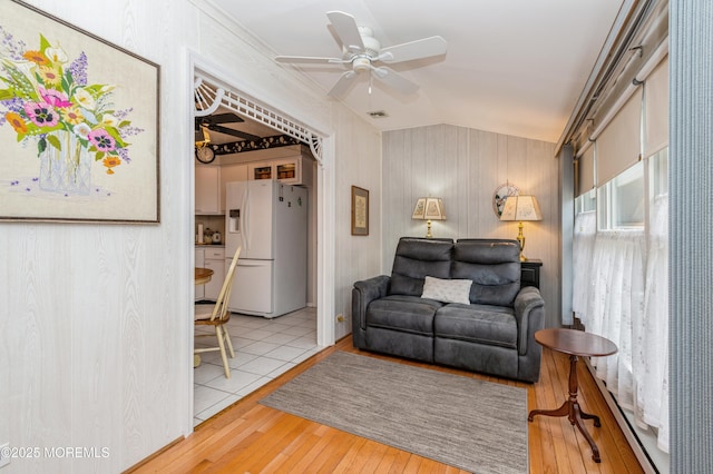 living area featuring visible vents, a ceiling fan, vaulted ceiling, and hardwood / wood-style floors