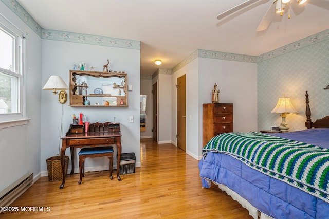 bedroom with wallpapered walls, light wood-style flooring, baseboards, and baseboard heating