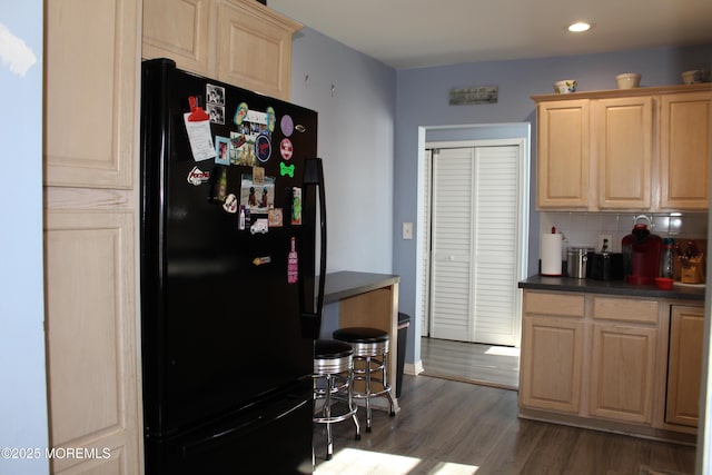 kitchen with dark wood-style floors, light brown cabinets, backsplash, and freestanding refrigerator