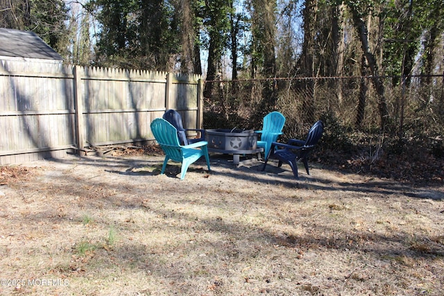 view of yard with a fire pit and fence